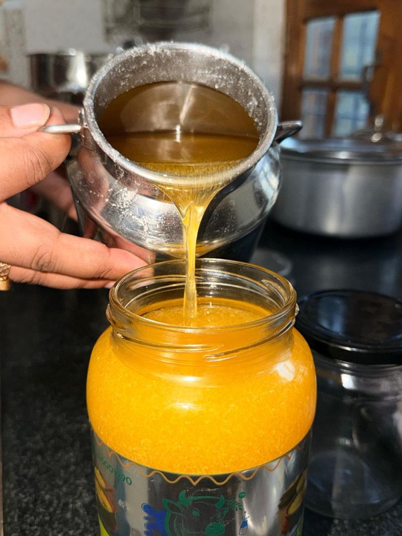 Straining fresh ghee into a jar